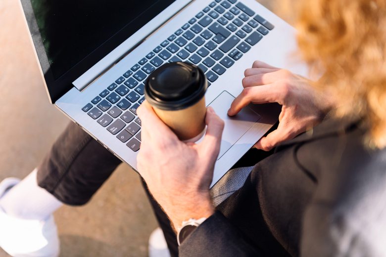 Hombre trabajando con un portátil en una mesa de café en Madrid